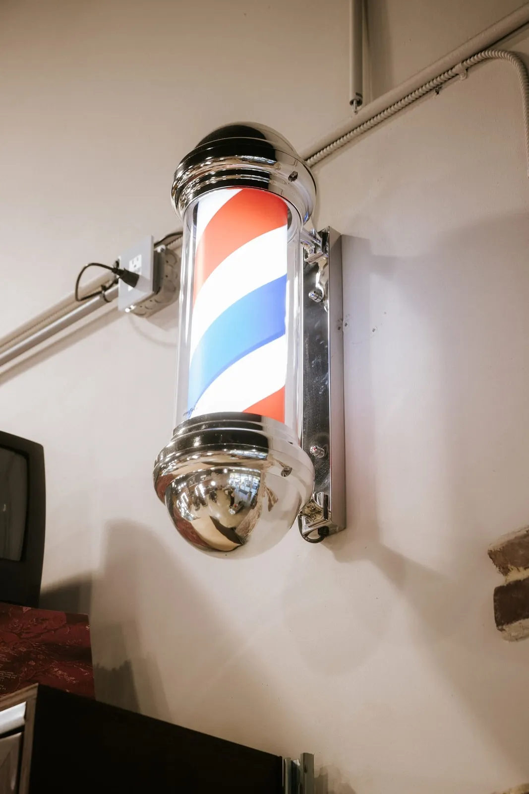 Red, white, and blue barber pole on the shop wall