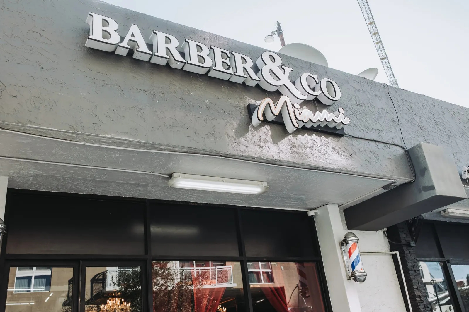 Barber & Co Miami sign and barber pole on the shop exterior