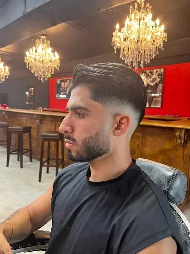High skin fade and short beard on a client by the shop bar