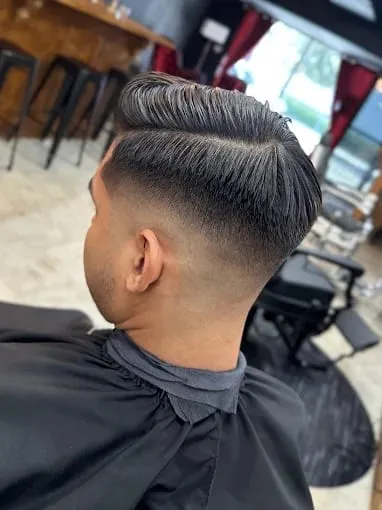 Side-part fade seen from behind in the barber chair