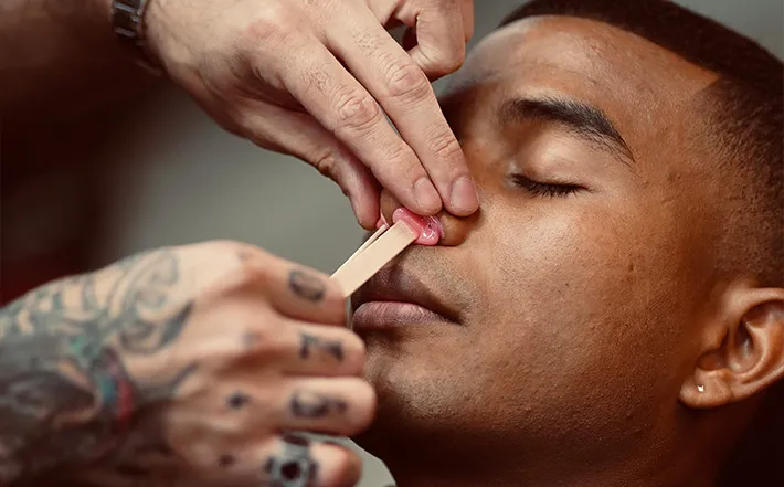 Close-up of a nose wax grooming service